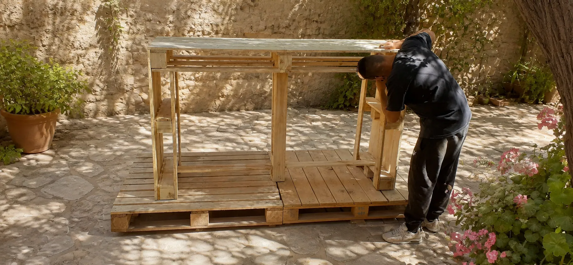 Proceso de construcción de mueble con pallets en patio